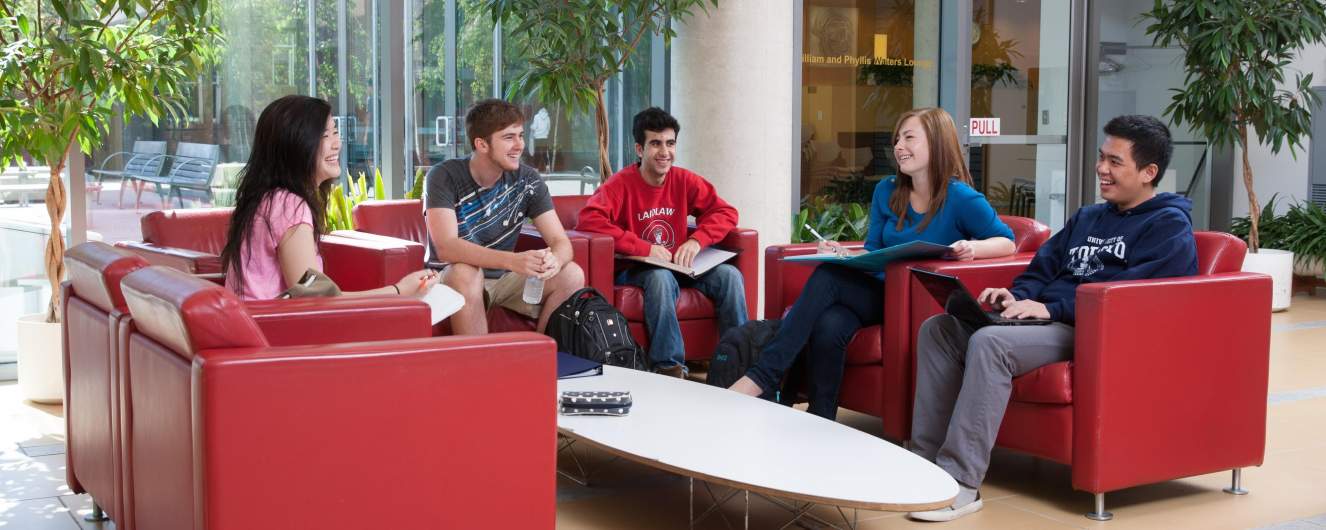 Five students chatting on the sofas in the residence lobby.